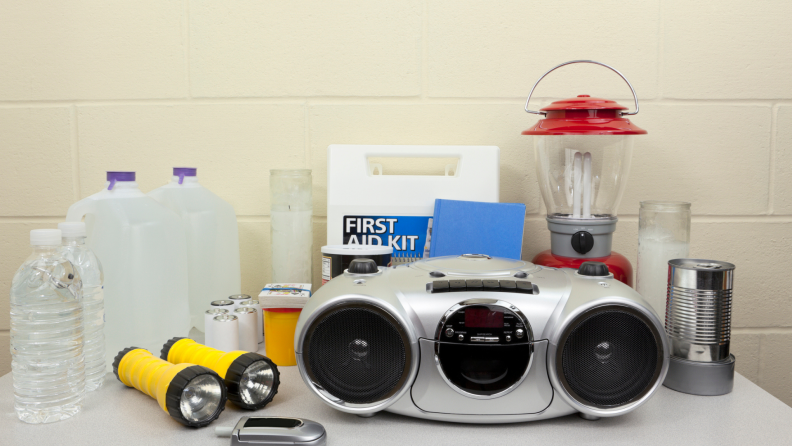 Emergency kit supplies including a stereo, lantern, first aid kit, backpack, flashlights, a water jug, and a few smaller items