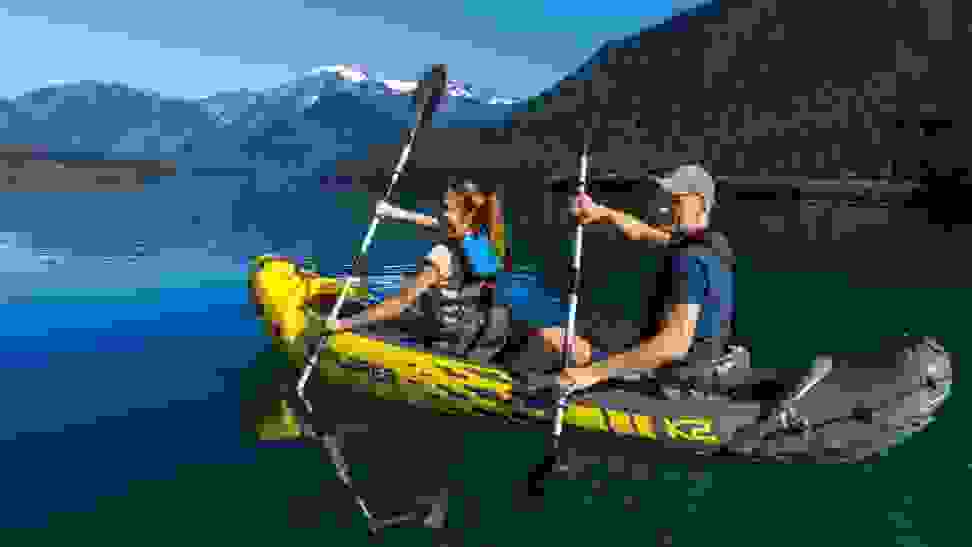 Photo of two people paddling a yellow Intex Explorer inflatable kayak on a body of water.