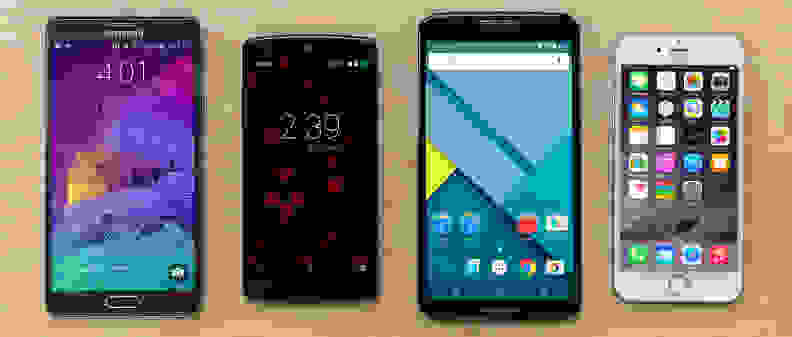 A photo of the Samsung Galaxy Note 4, Google Nexus 5, Google Nexus 6, and Apple iPhone 6 on wood.