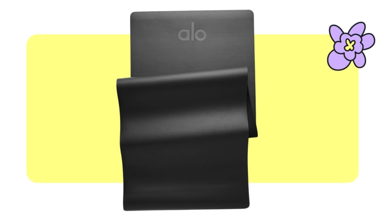 A black Alo Yoga mat folded up.