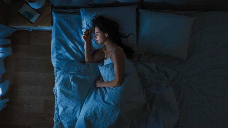 A woman sleeping on her side in bed.