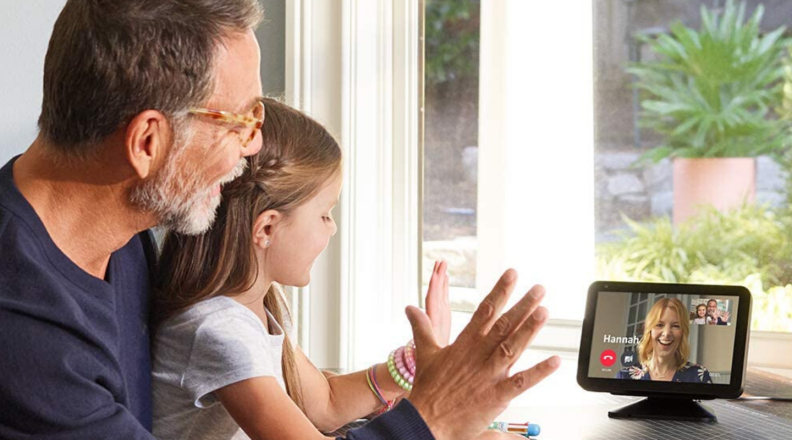 An adult and child participate in a video call using Amazon's Echo Show 5 smart display screen