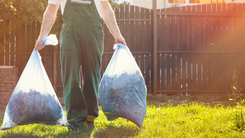 A person carries two bags of compost.