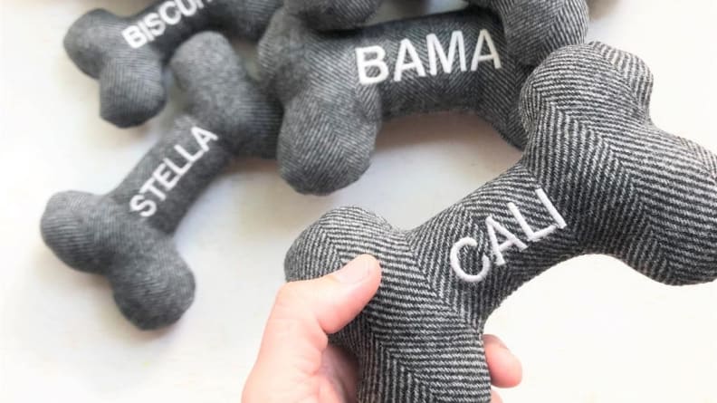 An image of several personalized dog toys in the shape of dog bones with different names on them.