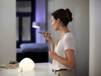 A woman uses Siri to control her Philips Hue lights