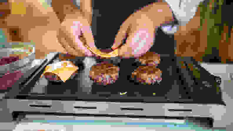 Grilling burger patties on an indoor grill.