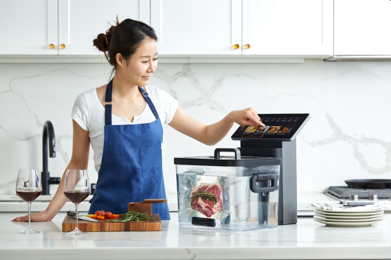 A person interacts with the screen of the Typhur sous vide station.