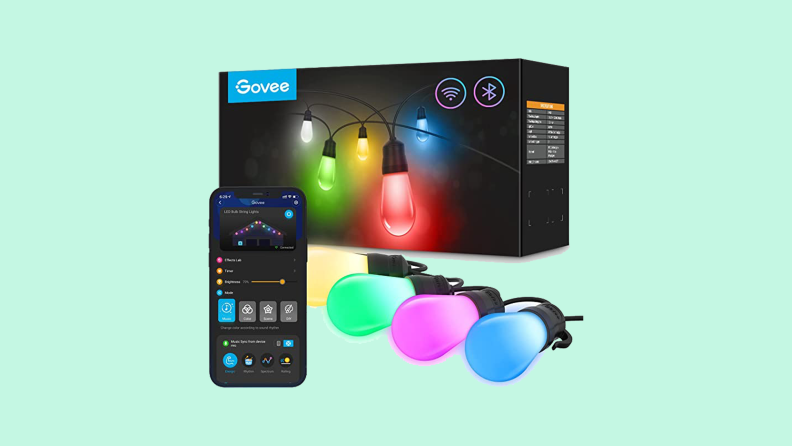 box of outdoor string lights with pink, blue, green lights next to light controlling app on phone