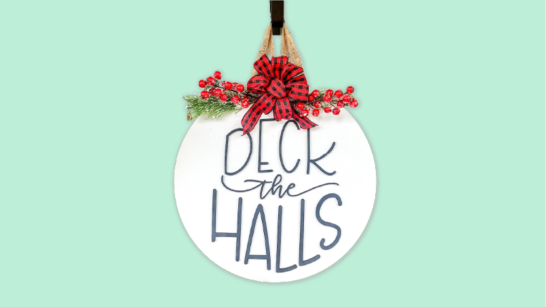 A wooden sign that reads 'Deck the Halls' against a blue background.