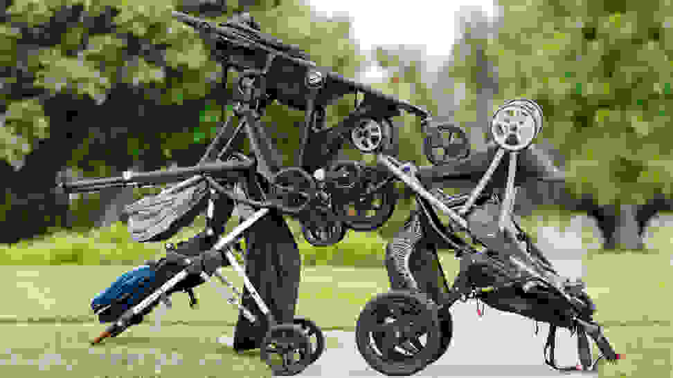 Photo of several strollers arranged on a park sidewalk.
