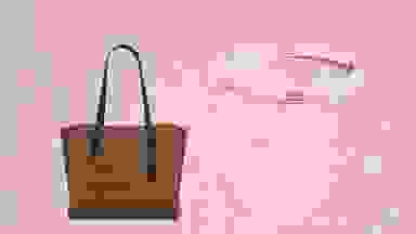 A Coach bag and bracelet against a pink backdrop.
