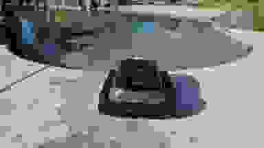The Aiper Scuba S1 pool cleaner on a concrete pool deck outdoors.