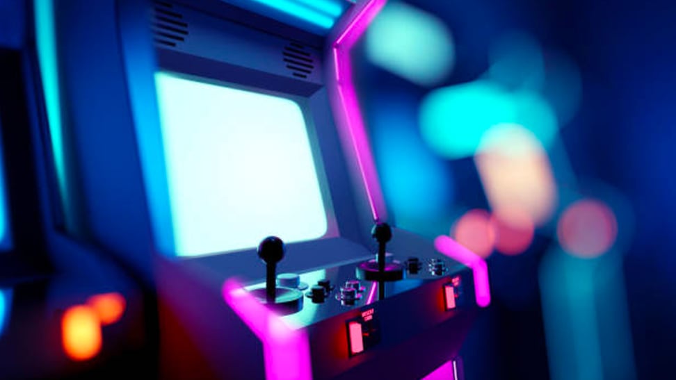 A picture of an arcade game highlighted in blue and pink lights, against a blurred background of an arcade.