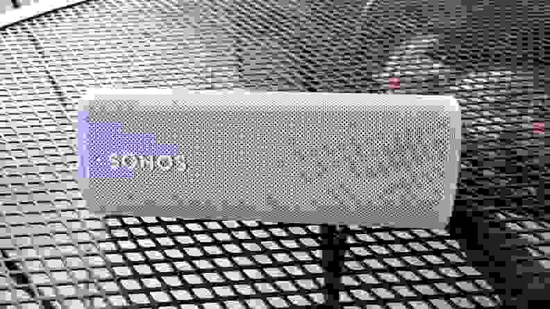 The white and tubular Sonos Roam set on a mesh metal table