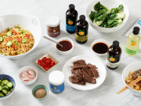 Assorted bowls of ramen, sauces and garnishments from Momofuku on granite countertop