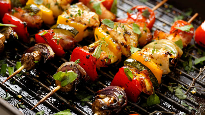 Vegetable skewers cooknig on a grill