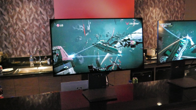 Two LG gaming desktop monitors with video games on display.