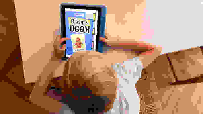A child reading Binder of Doom on an Amazon Fire 10