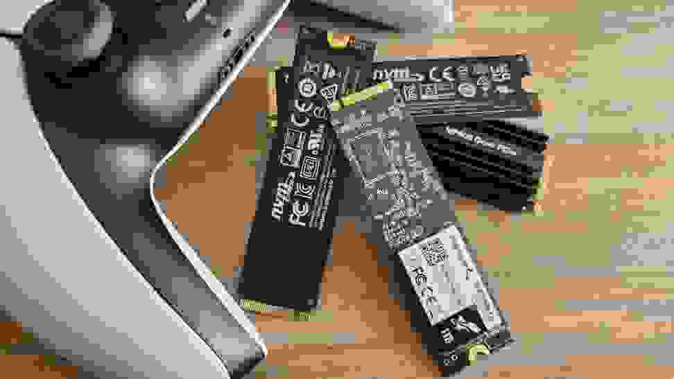 A collection of M.2 SSDs next to a gaming controller