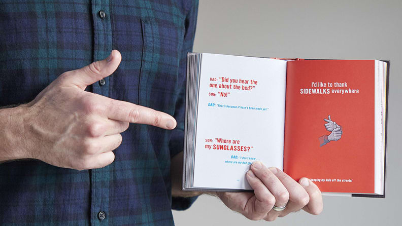 Guy pointing to a page in Essential Compendium of Dad Jokes