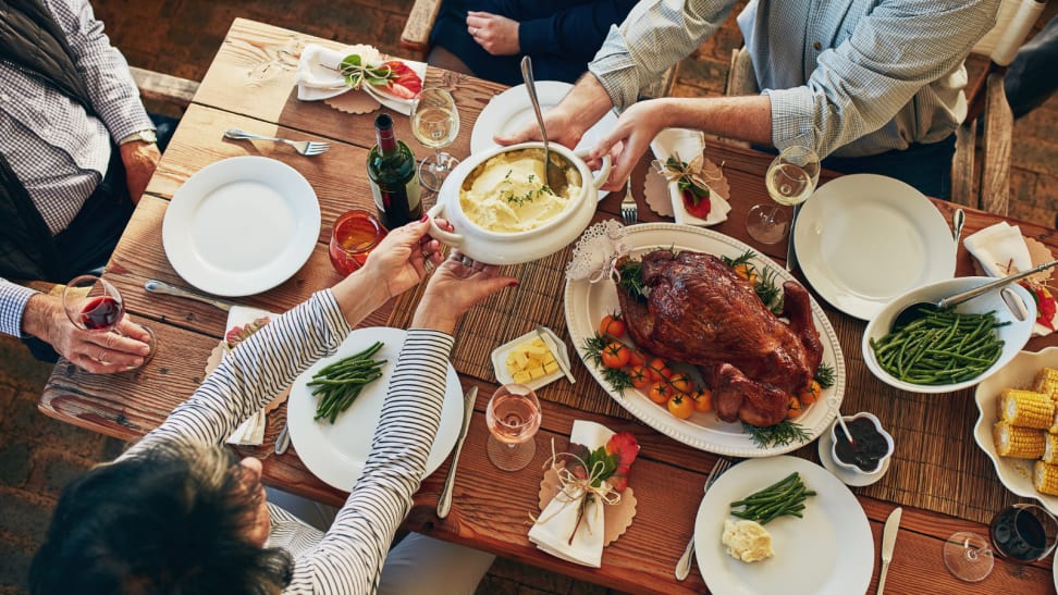 People passing dishes around a Thanksgiving table.