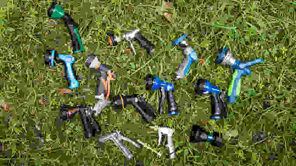 14 hose nozzles lay scattered on wet grass