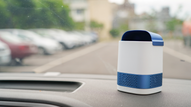 Luft Duo portable air purifier sitting on the dash of a car