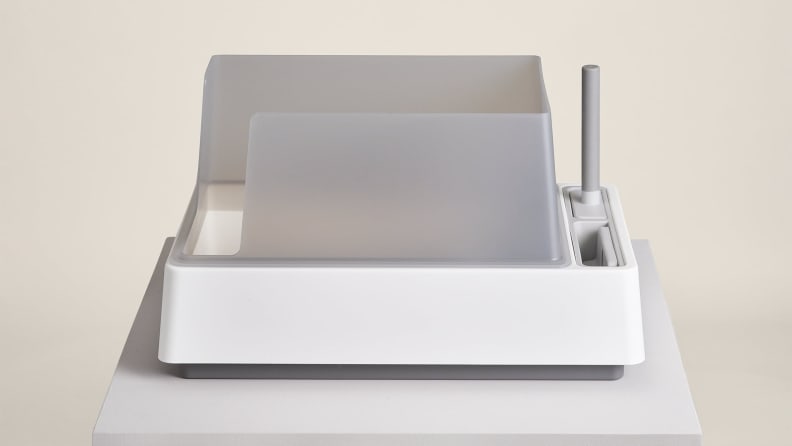 The Tuft + Paw litter box features high walls on three sides and slots for cleaning tools to the right.