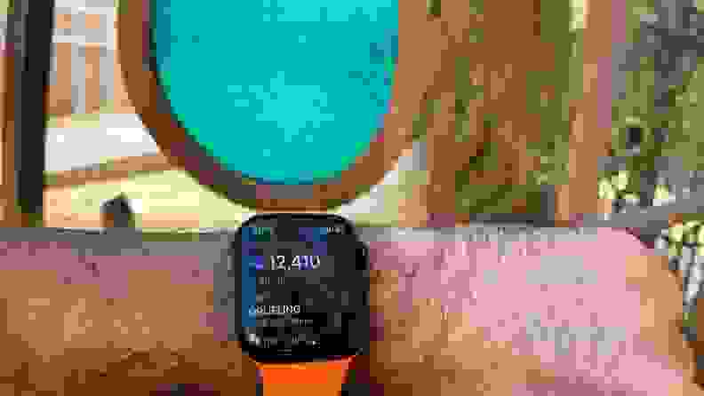 A person holds out their wrist to monitor how far they've walked on the Apple Watch's Oregon Trail app.