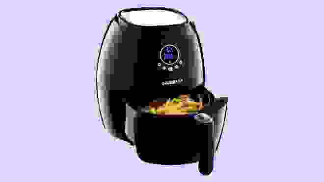 Black air fryer with french fries inside.