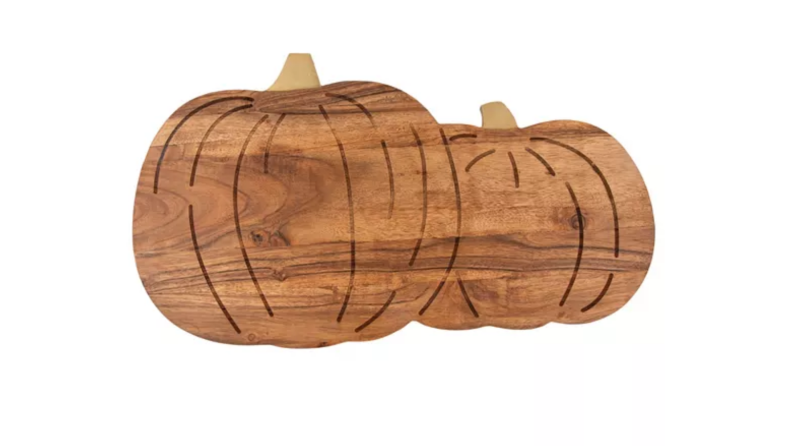 An image of a cutting board carved in the shape of two pumpkins next to one another.