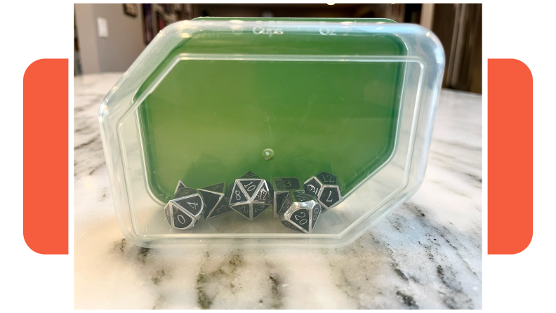 Plastic container with silver Dungeons & Dragons dice inside.