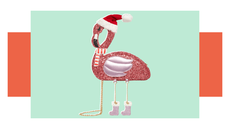 A glittered flamingo crossbody purse with a santa hat.