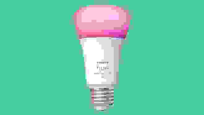 Pink smart bulb on green background