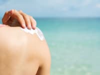 A woman applying sunscreen.