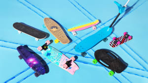 An assortment of beginner and kids' skateboards on a turquoise background