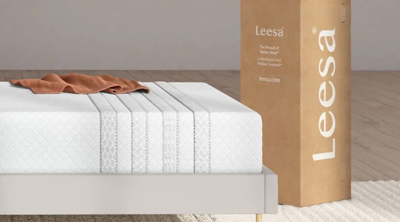 Leesa mattress on a bed frame with original packaging beside it