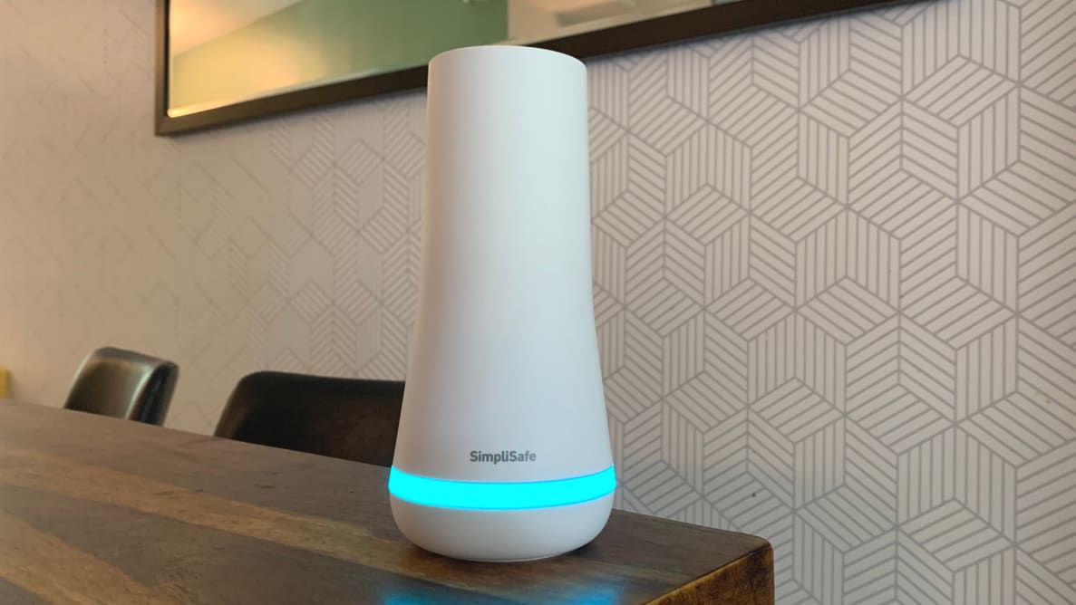 SimpliSafe base station sits son a wood dining room table.