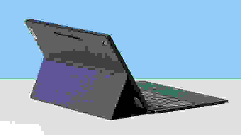 The Lenovo IdeaPad Duet 5 on a black kickstand, sitting on a white table.