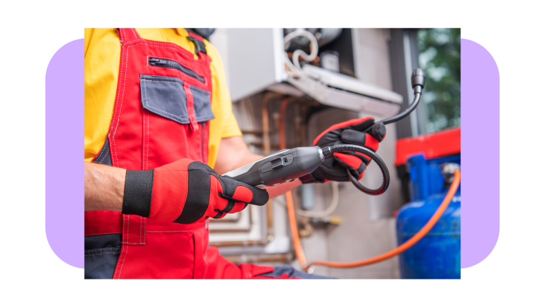 Technician using handheld gas detection machine outside of home to detect leak.