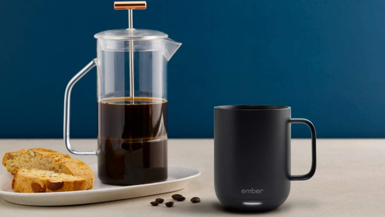 Ember mug and coffee press on brown table