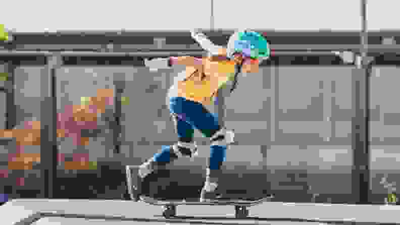 A girl gains some speed as she practices on her beginner kids skateboard