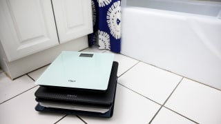 A stack of scales on a bathroom floor