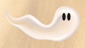 A swipe of suncreen lotion that looks like a ghost with back eyes over a sandy background