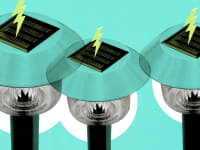 Solar panel lawn lights against a teal background