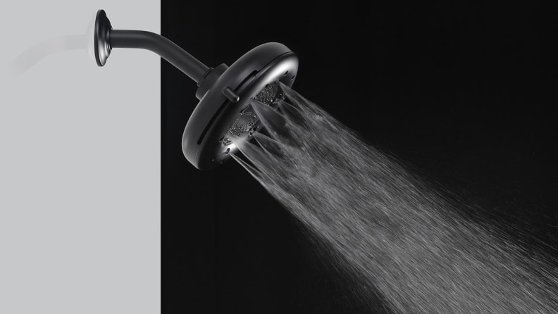 A black shower head spraying water.