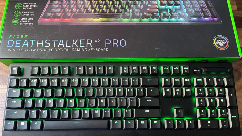 A Razer Deathstalker V2 Pro unboxed with green RGB lights.