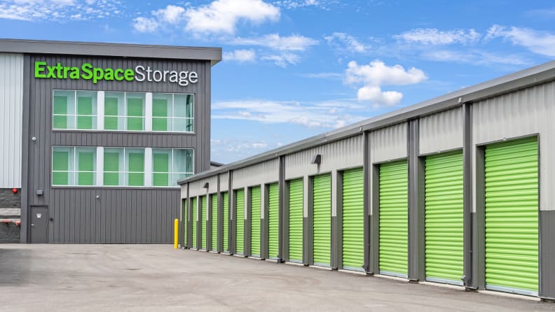 A parking lot with a large building and storage garages