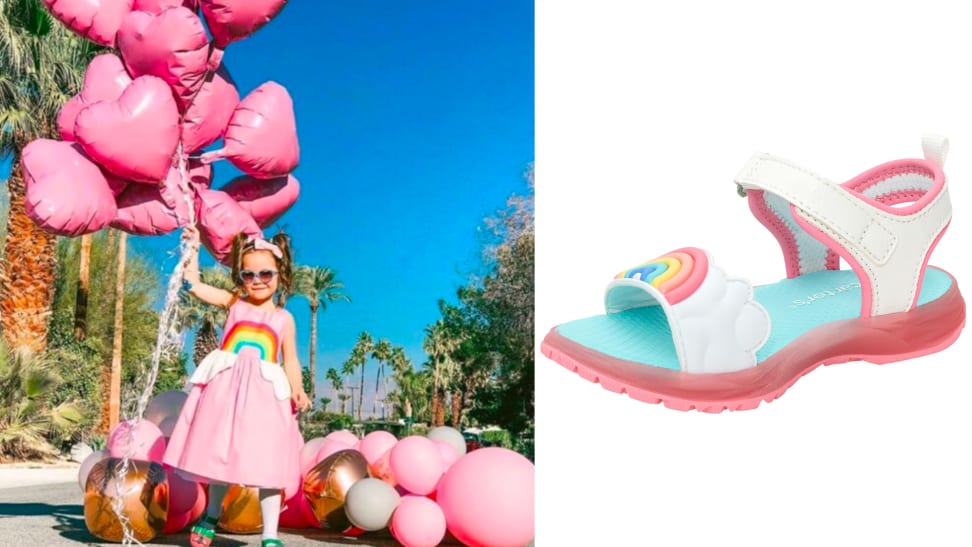 Child wearing a pink dress with a rainbow on the chest, holding pink heart-shaped balloons, next to a rainbow-colored sandal on a white background