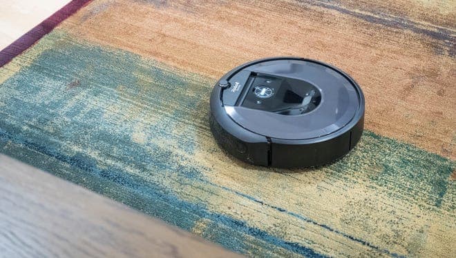 An Roomba vacuum on a rug.